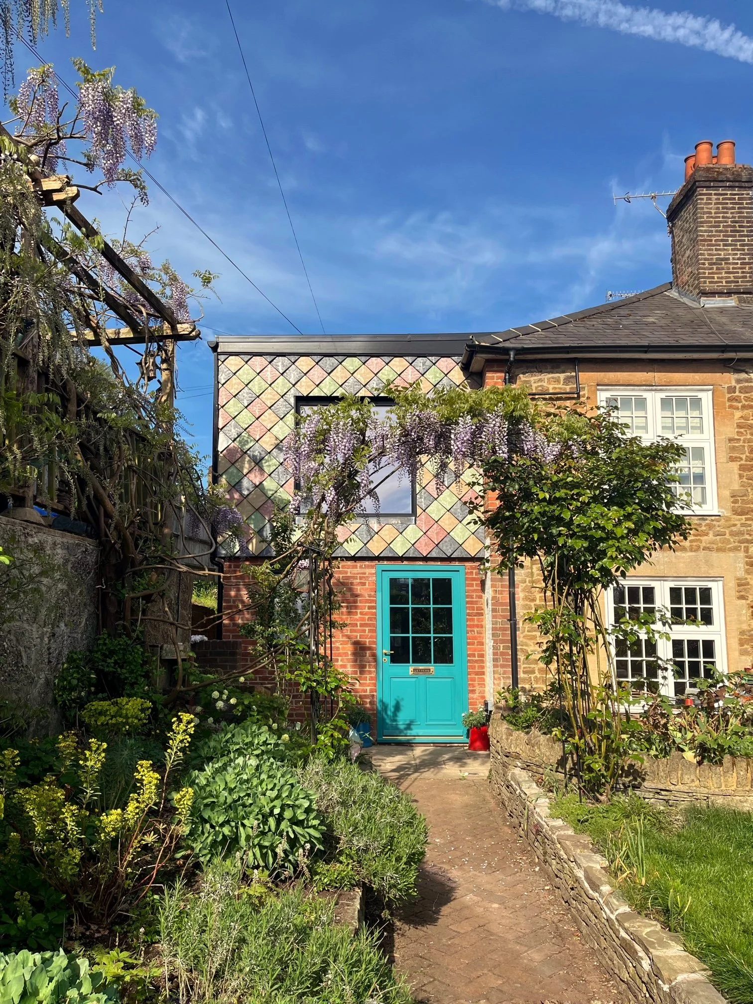 View from the garden showing how Pretty Plastic’s recycled façade tiles enhance the extension’s visual identity and environmental performance.