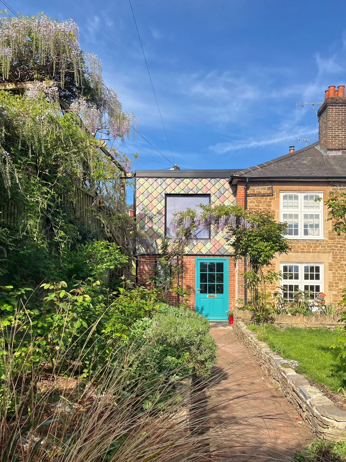 View from the garden showing how Pretty Plastic’s recycled façade tiles enhance the extension’s visual identity and environmental performance.