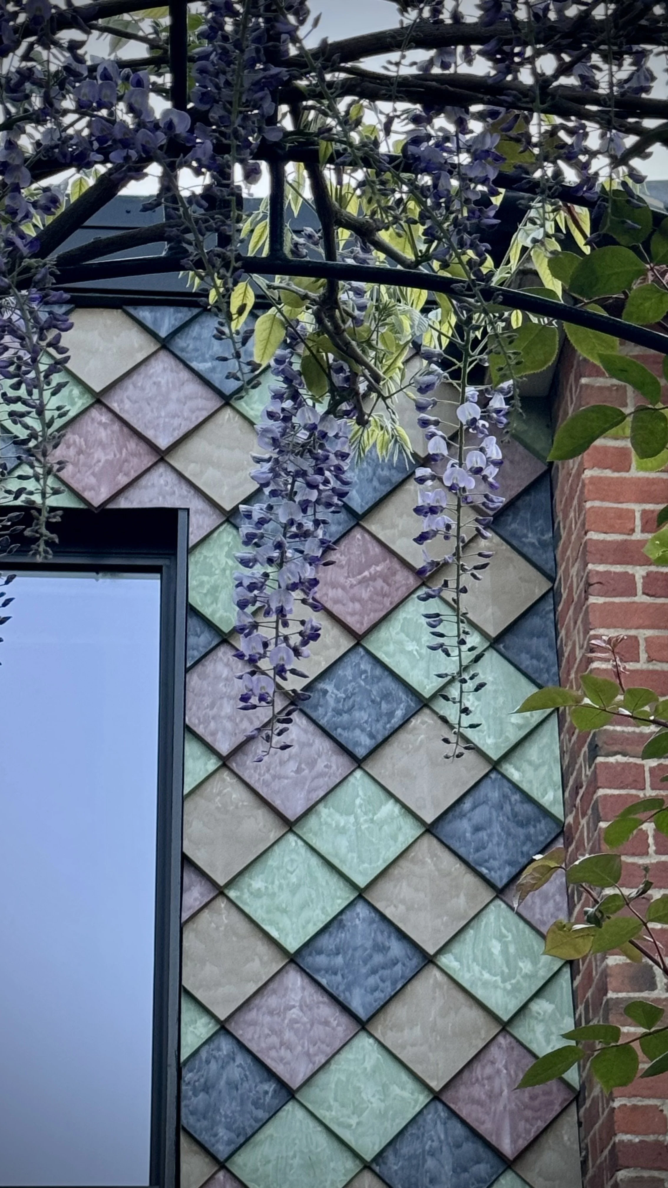 Façade view featuring Pretty Plastic’s colourful recycled PVC tiles surrounding a single window – demonstrating how bold, sustainable materials integrate seamlessly with modern residential design.