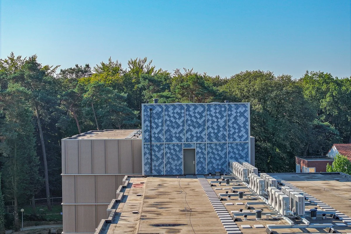 Ontdek De Vijverhof in Berg en Dal, waar duurzaamheid hoog in het vaandel staat. Met een oppervlakte van 240m² en ontworpen door INBO, is dit project een toonbeeld van innovatie. De foto toont het gebouw met zijn opvallende dak, gemaakt met First One