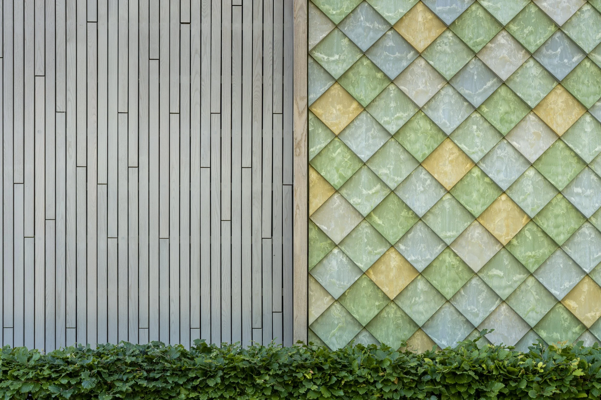 Detail of recycled cladding on the renovated Lensen building next to other facade material – Pretty Plastic First One tiles.