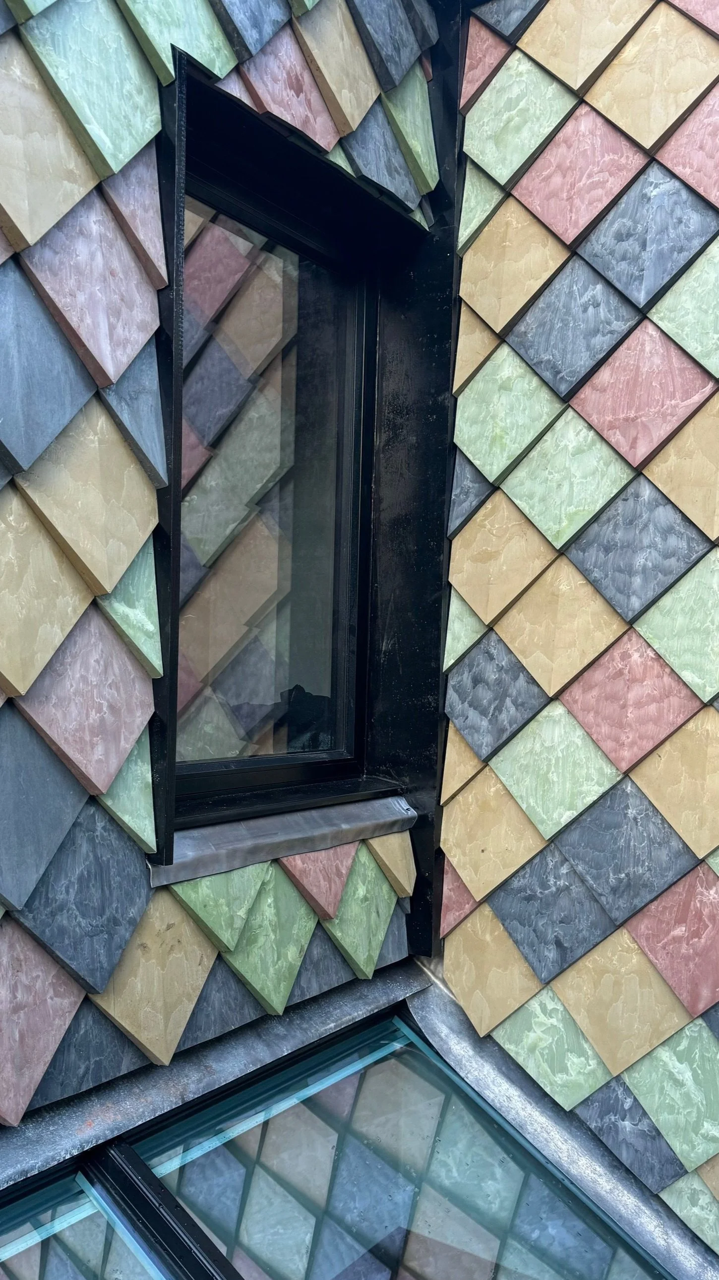 Close-up of Pretty Plastic’s 100% recycled PVC façade tiles, showing texture and colour variation on a sustainable extension.