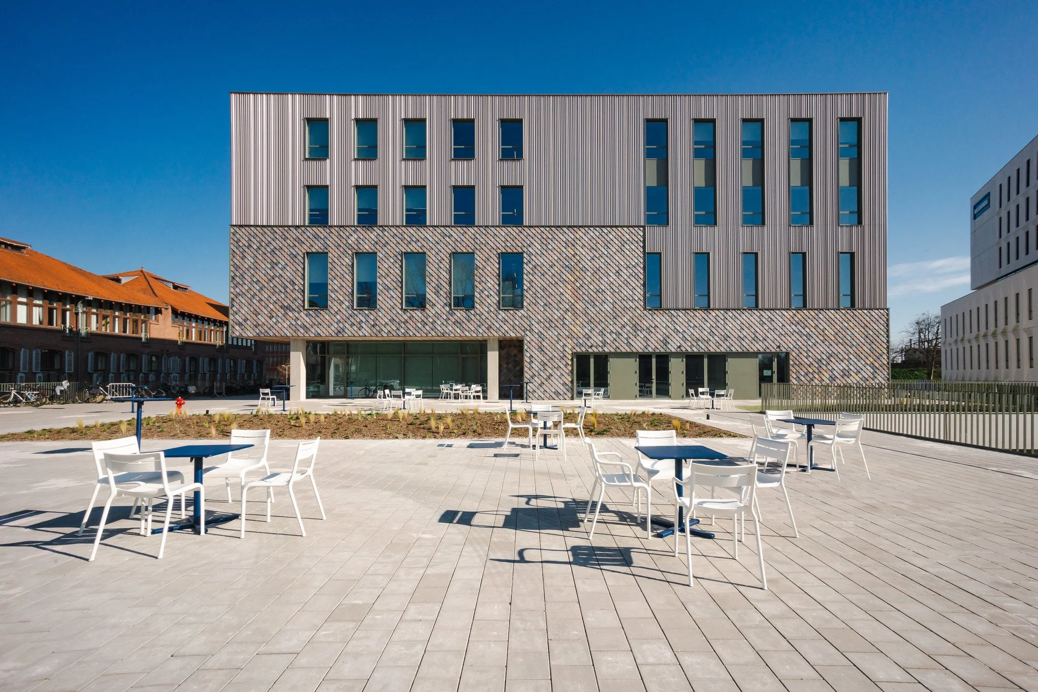 Zijkant gebouw met stoeltjes ervoor Howest 2024.jpg