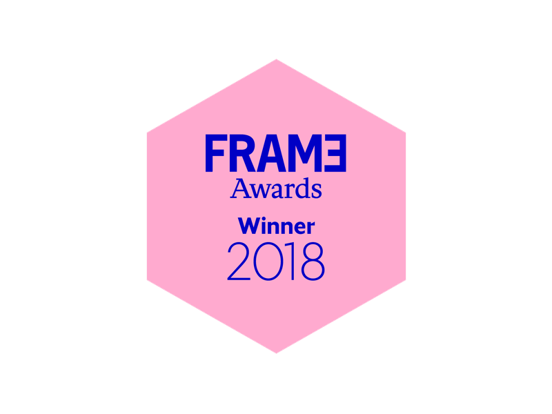 A pink hexagon award badge with the text 'FRAME Awards Winner 2018' in blue and purple font, against a black background.